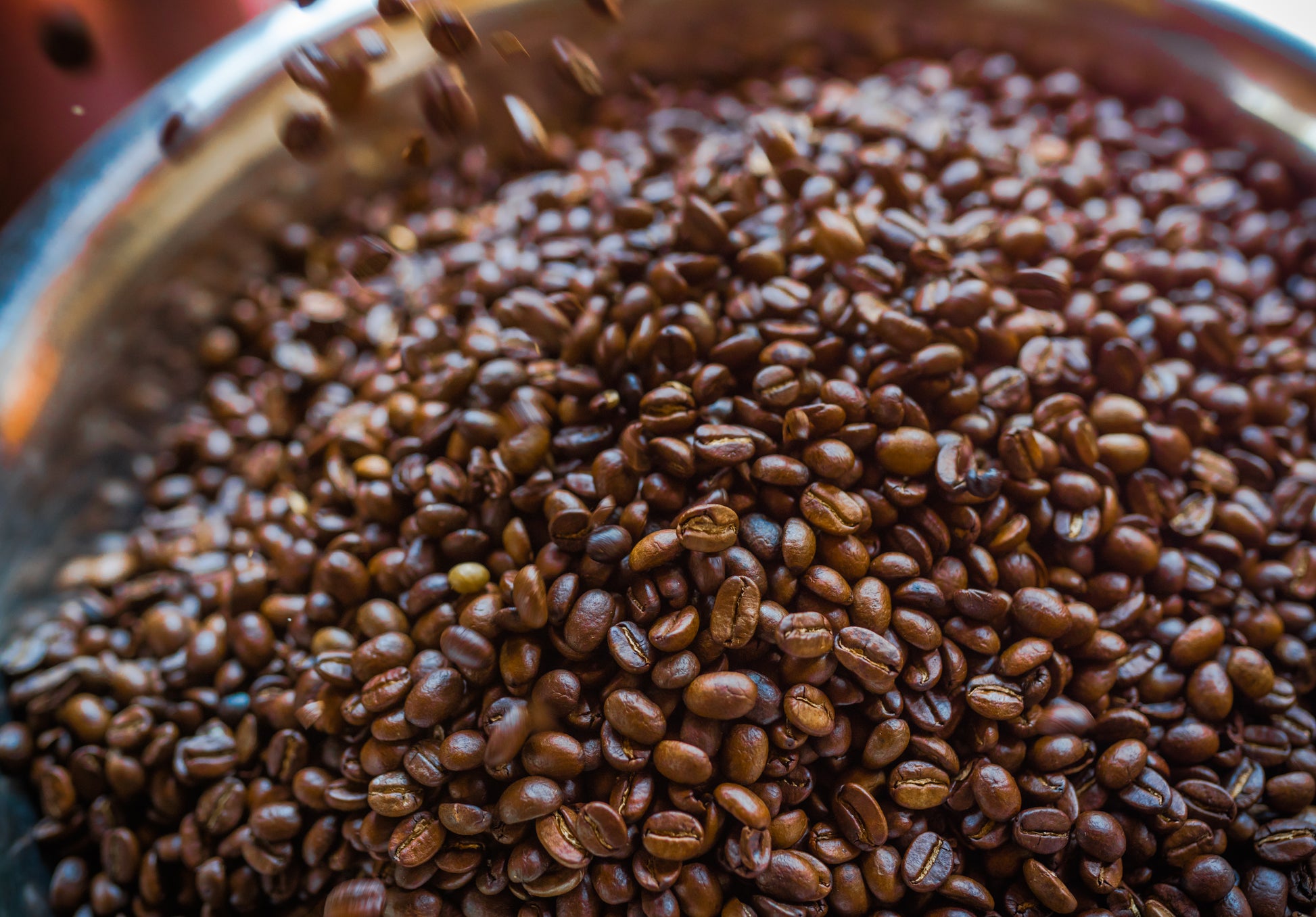 Freshly roasted coffee beans tumbling into the roaster drum